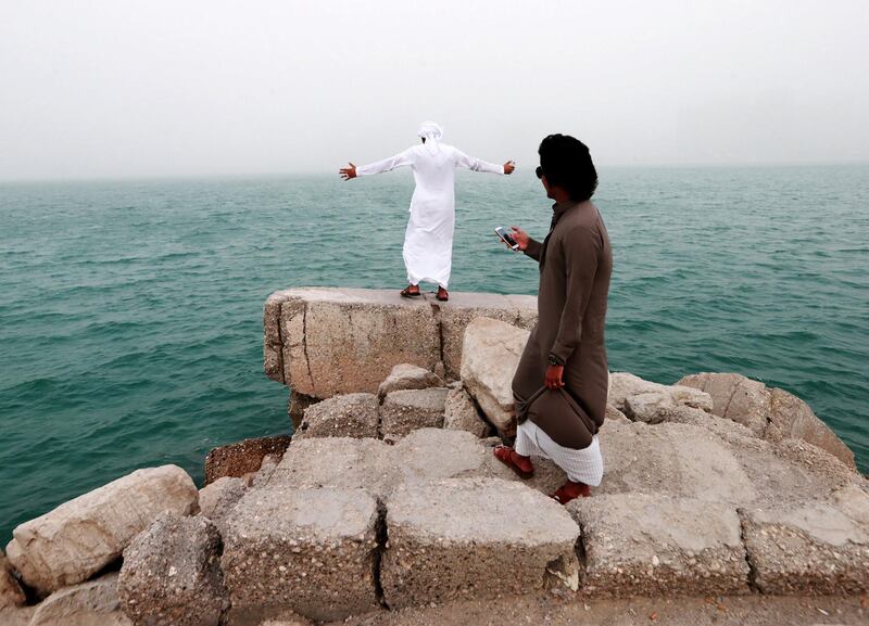 Abu Dhabi, United Arab Emirates, August 17, 2014:     A pair of Emirati boys take in the sandstorm from the Breakwater in Abu Dhabi on August 17, 2014. Christopher Pike / The National

Reporter:  N/A
Section: News