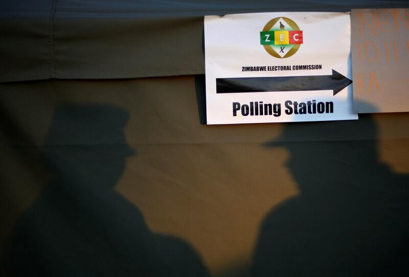 Shadows of police officers are cast on a tent of a polling station during the Zimbabwean general elections in Harare, Zimbabwe. REUTERS / Siphiwe sibeko