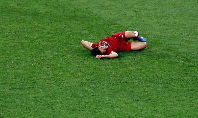 Liverpool's Mohamed Salah lies on the pitch after a collision with Real Madrid's Sergio Ramos. Darko Vojinovic / AP Photo