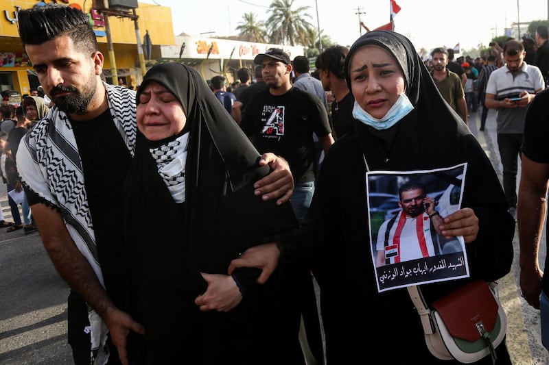 TOPSHOT - Mourners react as they march during a funerary procession for renowned Iraqi anti-government activist Ihab al-Wazni (Ehab al-Ouazni) in the central holy shrine city of Karbala on May 9, 2021 following his assassination. Wazni, a coordinator of protests in the Shiite shrine city of Karbala, was a vocal opponent of corruption, the stranglehold of Tehran-linked armed groups and Iran's influence in Iraq. He was shot overnight outside his home by men on motorbikes, in an ambush caught on surveillance cameras. He had narrowly escaped death in December 2019, when men on motorbikes used silenced weapons to kill fellow activist Fahem al-Tai as he was dropping him home in Karbala, where pro-Tehran armed groups are legion. / AFP / Mohammed SAWAF
