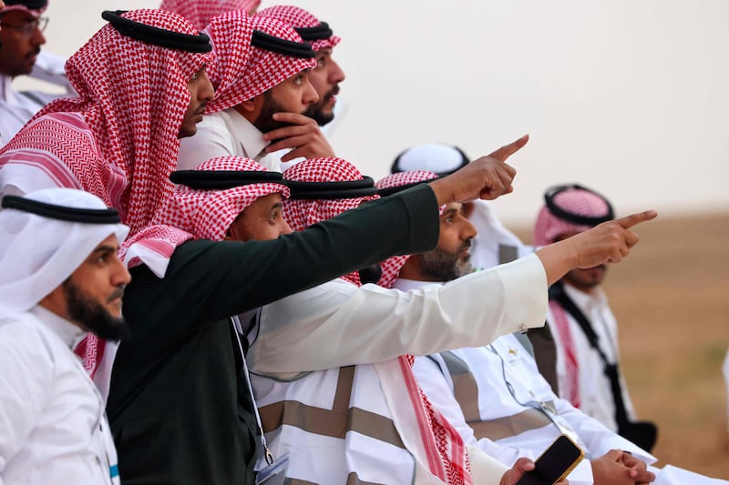 Saudi men look to spot the first crescent of the moon in the southern city of Hautat Sudair. AFP