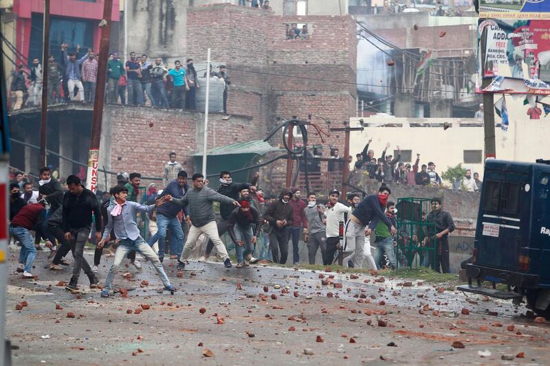 FILE - In this Feb. 15, 2019 file photo, protestors throw stones during a clash between communities after the Feb. 14 attack on a paramilitary convoy in Kashmir, in Jammu, India. India's top court on Friday, Feb. 22 ordered state authorities to stop threats, assaults and social boycotts of thousands of Kashmiri students, traders and professionals in an apparent retaliation for the killing of 40 paramilitary soldiers in a suicide attack in the Indian portion of Kashmir last week. The attack in the Muslim-majority Kashmir Valley has raised tensions elsewhere in Hindu-majority India, where Kashmiri Muslims in many cities are increasingly facing a backlash in the form of attacks mainly on students, job suspensions and eviction from rented apartments. (AP Photo/Channi Anand, File)