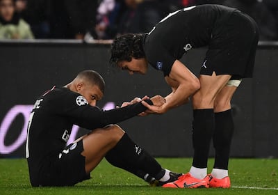 Paris Saint-Germain's Uruguayan forward Edinson Cavani (R) tries to cheer up Paris Saint-Germain's French forward Kylian Mbappe at the end of the UEFA Champions League round of 16 second-leg football match between Paris Saint-Germain (PSG) and Manchester United at the Parc des Princes stadium in Paris on March 6, 2019. / AFP / FRANCK FIFE
