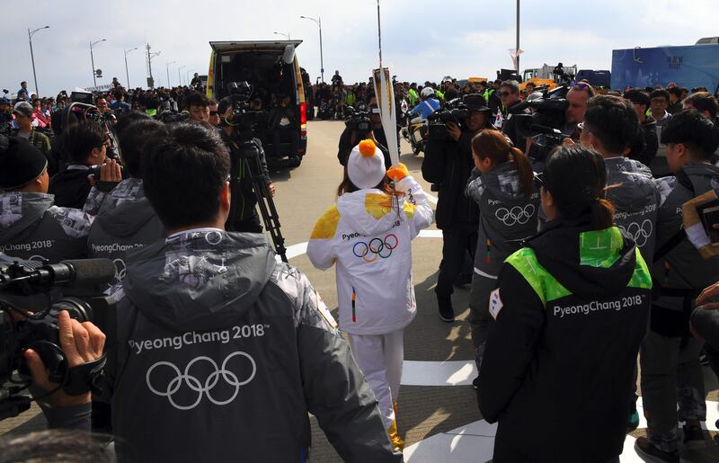 South Korean figure skater You Young, centre, the first torchbearer of the country, carries a torch during a ceremony of the start the Olympic torch relay across South Korea at Incheon bridge, west of Seoul, on November 1, 2017.
The Olympic flame arrived in South Korea on November 1, 100 days ahead of the opening ceremony for the 2018 Pyeongchang Winter Games. Jung Yeon-Je / AFP