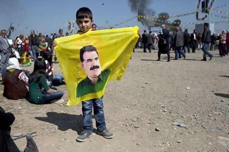 A Kurdish boy holds a banner of Abdullah Ocalan, the jailed leader of the PKK at Newroz festivities in Diyarbakir. 