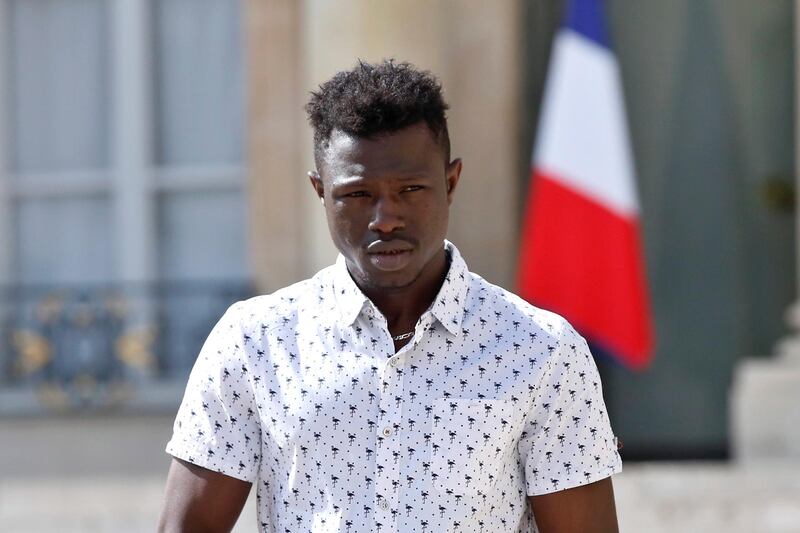epa06768273 Mamoudou Gassama from Mali leaves the presidential Elysee Palace after his meeting with French President Emmanuel Macron in Paris, France, 28 May 2018. The 22 year old migrant Mamoudou Gassama, who is living in France illegally, is being honored by Macron for scaling an apartment building over the weekend to save a 4-year-old child dangling from a fifth-floor balcony.  EPA/THIBAULT CAMUS / POOL MAXPPP OUT
