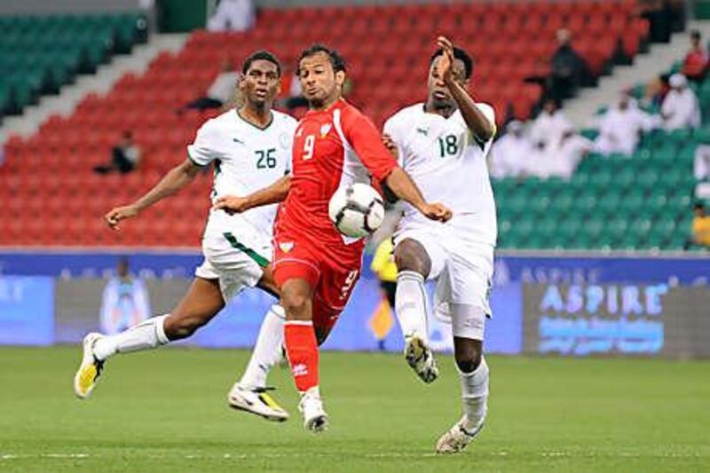 Ahmed Ali, centre, the UAE striker, fends off the challenge of two Saudi Arabia defenders during Friday night's 1-0 win.