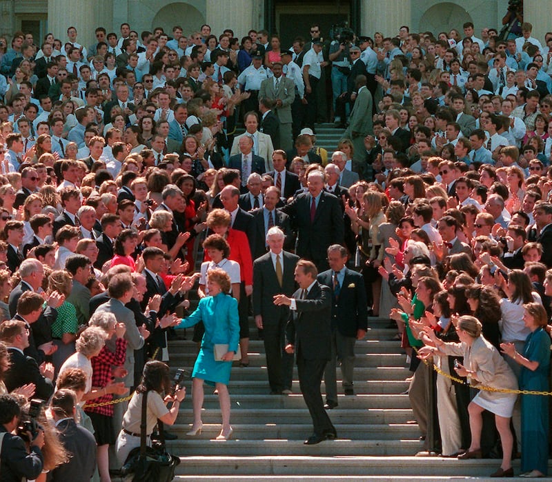Former majority leader Dole and his wife Elizabeth are escorted by senators as they leave Capitol Hill after his official retirement in June 1996. AP