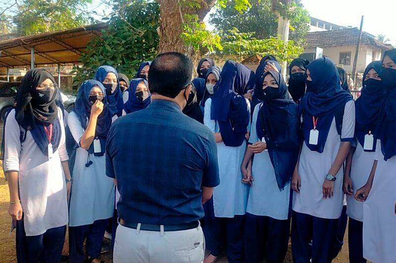 Hijab-wearing students speak to their principal outside a college campus in Udupi. AP