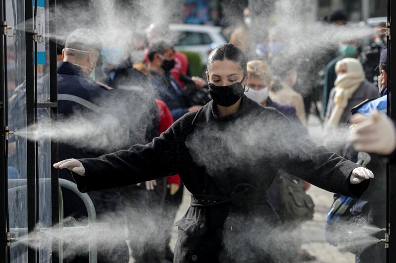 People are disinfected before entering a market, as Albanian authorities take measures to stop the spread of the coronavirus disease (COVID-19), in Tirana, Albania. REUTERS