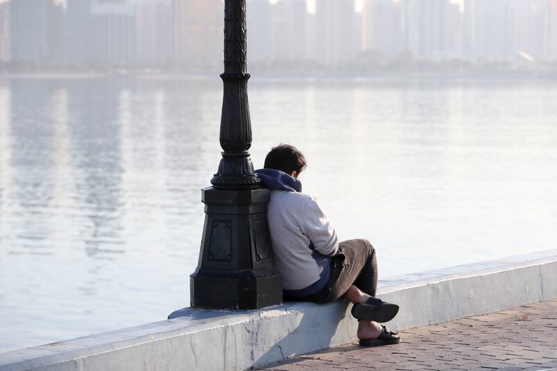 As temperatures drop, this UAE resident wraps up against the cold along the Corniche in Abu Dhabi. Khushnum Bhandari / The National