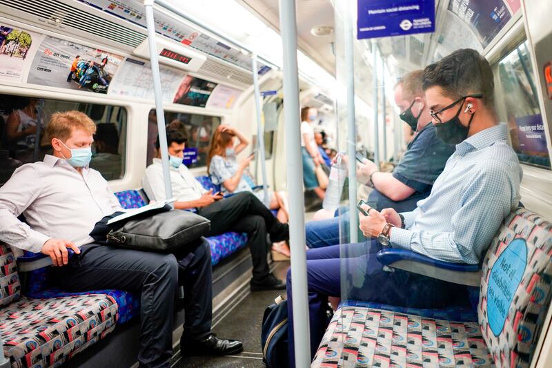 People wear masks on an Underground train in London.