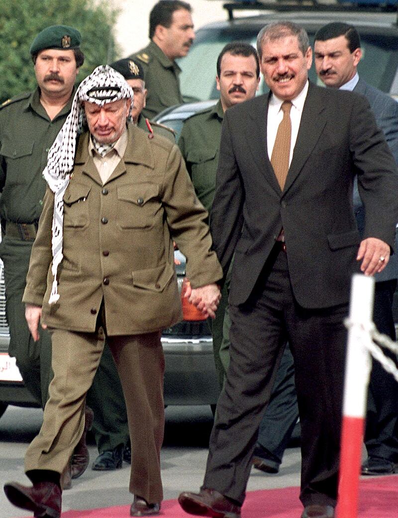 Yasser Arafat, then-president of the Palestinian Authority, walks hand-in-hand with Jordan’s then-prime minister Fayez Tarawneh, in Gaza city.. AFP