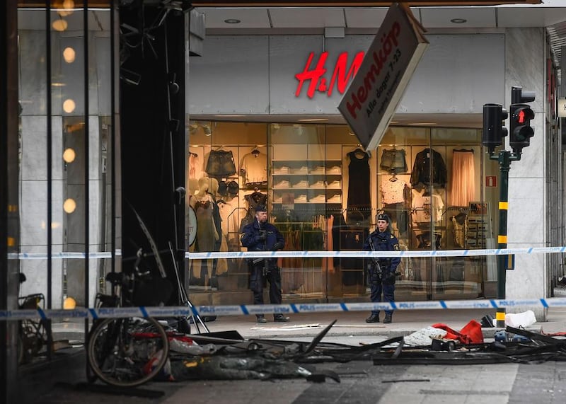 Police officers guard at the site where a man killed three after driving a van into a crowd in Stockholm on April 8, 2017(AFP)