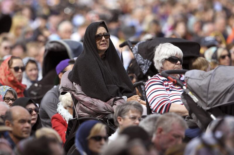 Members of the public look on during a gathering for congregational Friday prayers and two minutes of silence for victims of the twin mosque massacre at Hagley Park. AFP