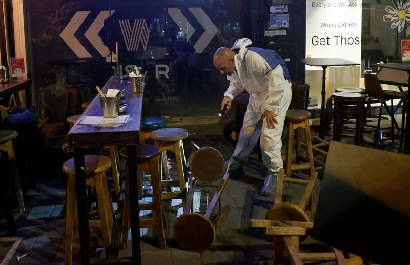 A forensics expert gathers evidence at the restaurant in Tel Aviv. AFP