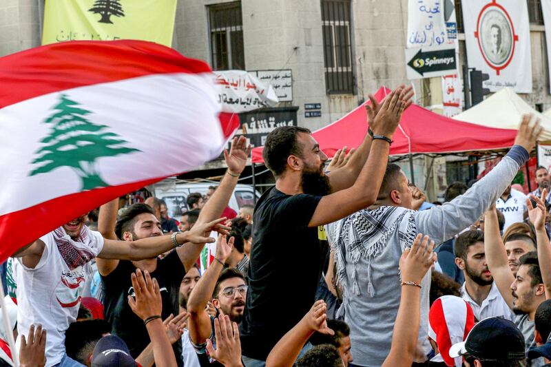 Lebanese anti-government protesters celebrate the resignation of Prime Minister Saad Hariri in the southern city of Sidon on October 29, 2019 on the 13th day of anti-government protests. (Photo by Mahmoud ZAYYAT / AFP)