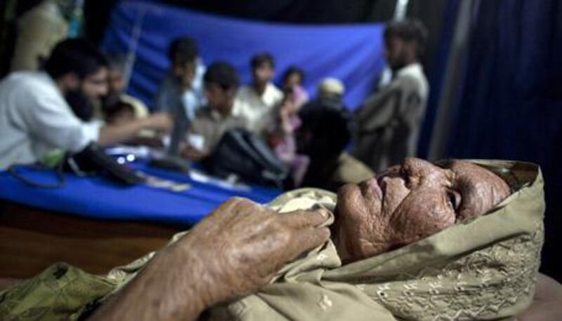 An elderly displaced woman waits to see a doctor at the Chota Lahore camp on June 8 in Swabi, Pakistan.