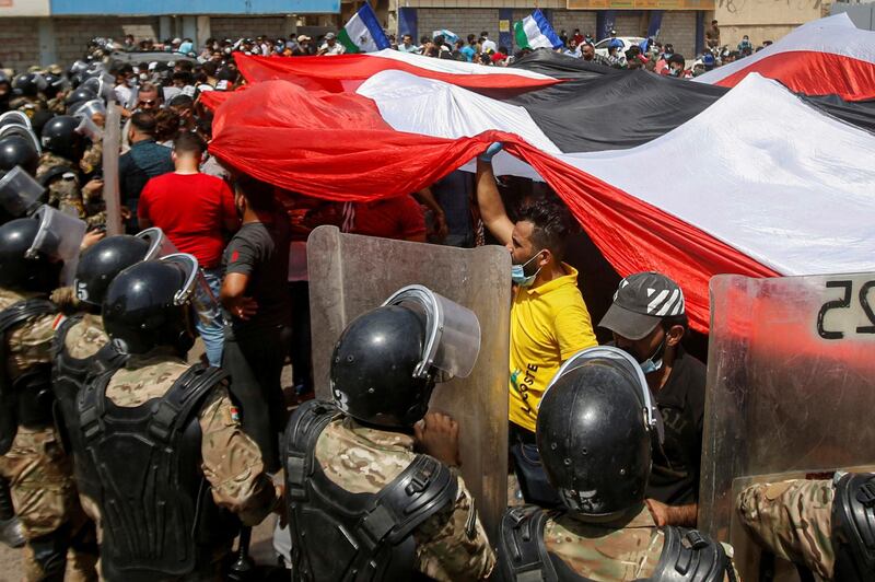 Iraqi security forces stand in front of demonstrators in anti-government protests during Iraqi Prime Minister Mustafa Al Kadhimi's visit, in Basra, Iraq. Reuters