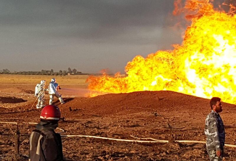 Syrian firefighters extinguish the flames of a gas pipeline that hit by an explosion SANA HO via Reuters