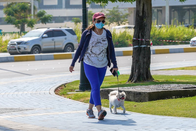 Abu Dhabi, United Arab Emirates, May 27, 2020.  A lady walks her dog on a hazy day along the Corniche, Abu Dhabi.
Victor Besa  / The National
Section:  Standalone / Stock