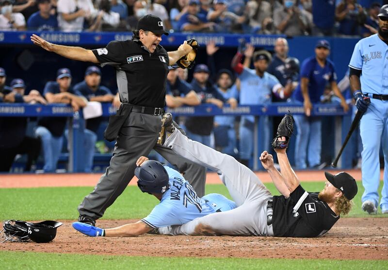 Umpire James Hoye signals that Toronto Blue Jays' Breyvic Valera is safe at home after a wild pitch by Chicago White Sox' Craig Kimbrel during the MLB game at Rogers Centre in Canada on Monday, August 23. USA TODAY Sports