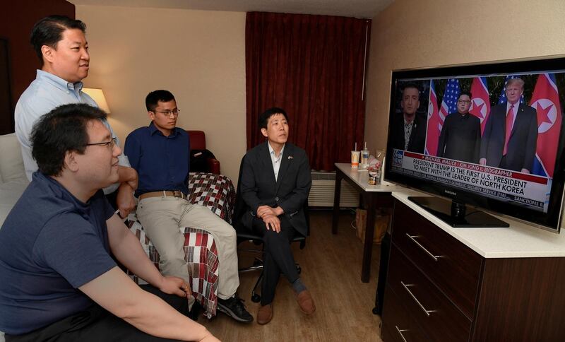 North Korean defectors Park Sang Hak and Justin Kim watch replays of US President Donald Trump's summit meeting in Singapore with North Korea leader Kim Jung Un on television, at a motel in Leesburg, Virginia. Also watching are South Korean human rights activists Do Hee Yun and Henry Song. Mike Theiler / Reuters