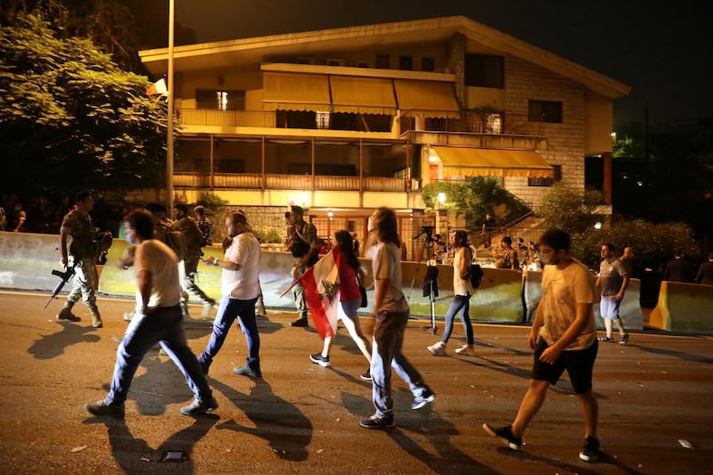 Protesters walk outside the home of Fairouz, one of Arab world's most famed singers, as French president Emmanuel Macron visits her, in Rabieh, Lebanon, on August 31, 2020. Reuters