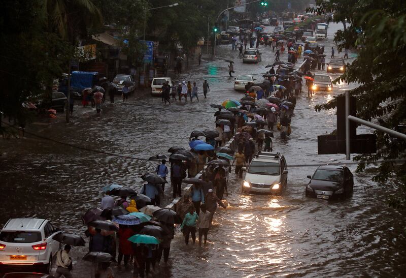 Commuters walk through water-logged roads after rains in Mumbai. Shailesh Andrade / Reuters