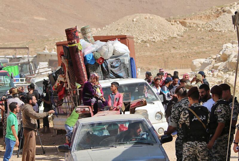 Lebanese security forces check identity and papers of Syrian refugees getting ready to cross into Syria from the eastern Lebanese border town of Arsal, Lebanon, on June 28, 2018. Stringer / AFP