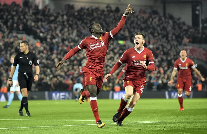 LIVERPOOL, ENGLAND - JANUARY 14:  Sadio Mane of Liverpool celebrates with team mate Andy Robertson after scoring the third Liverpool goal during the Premier League match between Liverpool and Manchester City at Anfield on January 14, 2018 in Liverpool, England.  (Photo by Shaun Botterill/Getty Images)