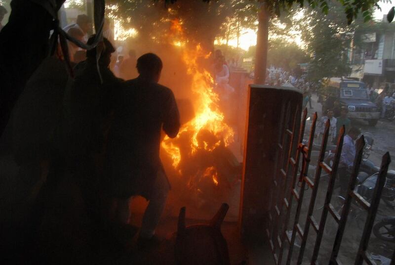 Indian bystanders attempt to douse the blaze as the Bahujan Samaj Party's Kamruzzama Fauji and a man named by police as Durgesh Kumar Singhb are engulfed in flames during an election television debate in a local park in Sultanpur, a town about 160 kilometres from the city of Lucknow. AFP Photo

