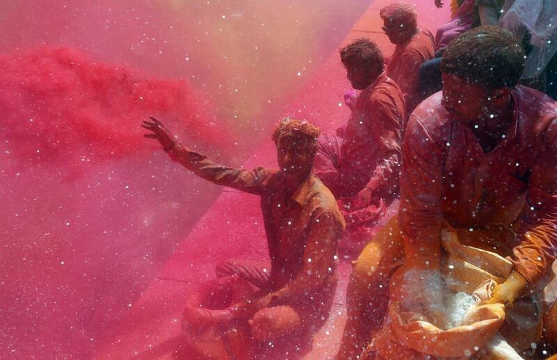 A man throws coloured powder on men and women during ‘Huranga’ at Dauji temple near the northern Indian city of Mathura. “Huranga” is a game played between men and women a day after Holi, the festival of colours, during which men drench women with liquid colours and women tear off the clothes of the men. Anindito Mukherjee / Reuters