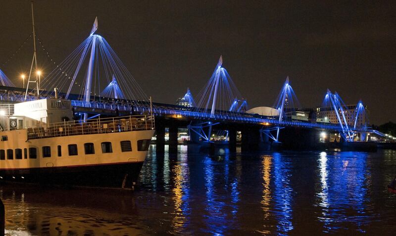 Blue lights illuminate the Golden Jubilee Bridges over the River Thames in central London on July 22, 2013. Prince William's wife Kate on July 22 gave birth to a baby boy who will one day inherit the British throne, Kensington Palace said in a statement.    AFP PHOTO / WILL OLIVER
 *** Local Caption ***  597898-01-08.jpg