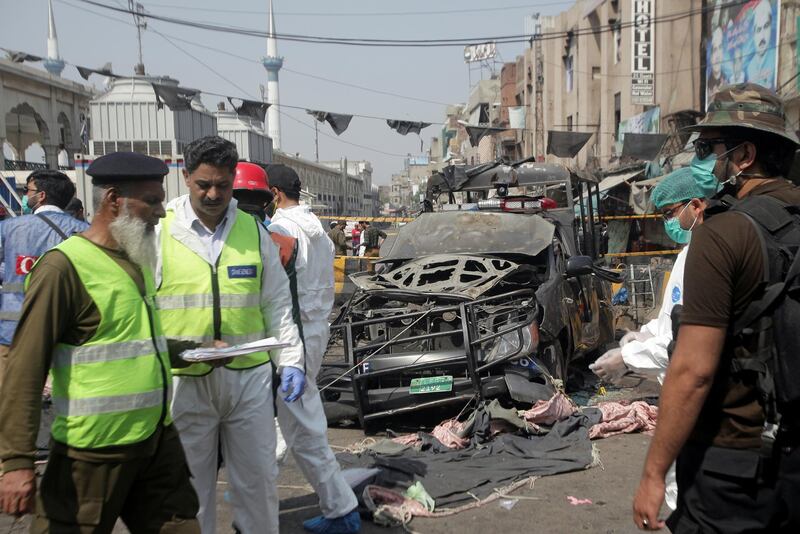 Security officials and members of a bomb disposal team survey the site after the blast. Reuters