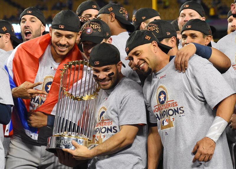 The Houston Astros' second baseman Jose Altuve, centre, and teammates celebrate with the Commissioner's Trophy after defeating the Los Angeles Dodgers at Dodger Stadium. Jayne Kamin-Oncea / Reuters