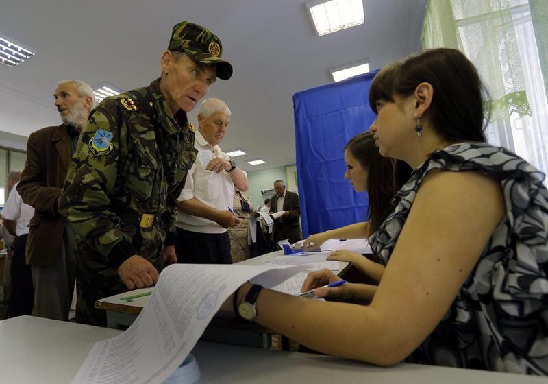 A Ukrainian veteran of the Maidan freedom movement registers to receive his ballot for the presidential elections, at a polling station in central Kiev, Ukraine. Robert Ghement/EPA
