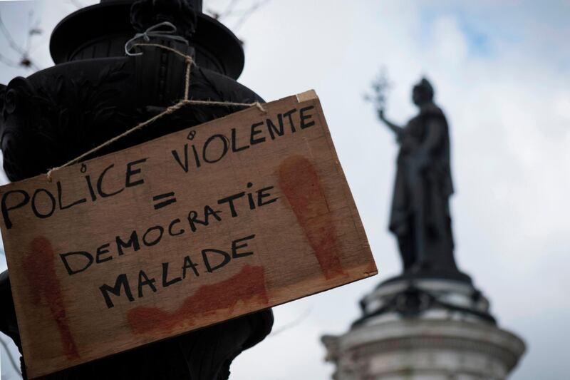 A picture shows a placard reading in French "Violent police = sick democracy" hanging from a pole Place de la Republique in Paris on February 3, 2019, a day after "Yellow Vest" (Gilets Jaunes) protesters took to the streets for the 12th consecutive Saturday. The "Yellow Vest" movement in France originally started as a protest about planned fuel hikes but has morphed into a mass protest against President's policies and top-down style of governing. / AFP / JOEL SAGET
