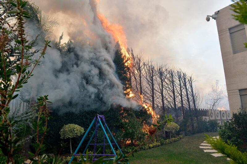 A fire is seen near a house in Mechref.  EPA