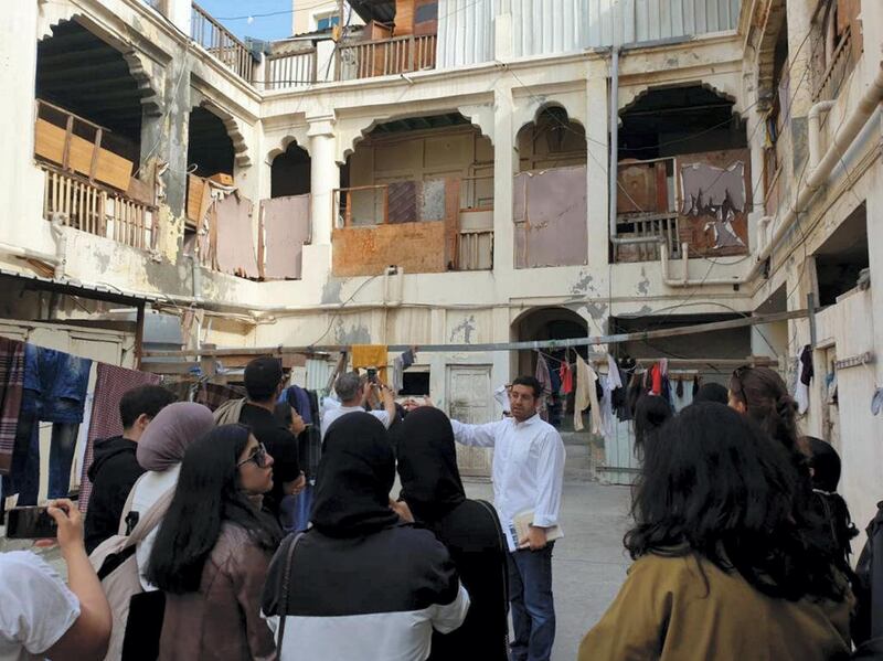 Bahraini architect Ali Karimi shows a group of onlookers an old school in Manama as part of a new series of tours taking in Bahrain's architecture. Nawal Abulkarim