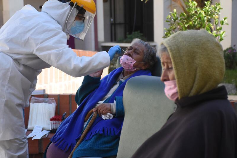 A health worker takes samples to test elderly residents for the coronavirus at the San Jose nursing home in Cochabamba, Bolivia.  AP Photo