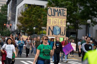 A demonstrator holds a sign that reads "Climate Justic Now" during the Global Climate Strike in Seattle, Washington, U.S., on Friday, Sept. 20, 2019. Thousands of workers at Microsoft Corp. and Amazon.com Inc. walked out without their bosses’ blessings to protest rising global temperatures. Photographer: Chloe Collyer/Bloomberg