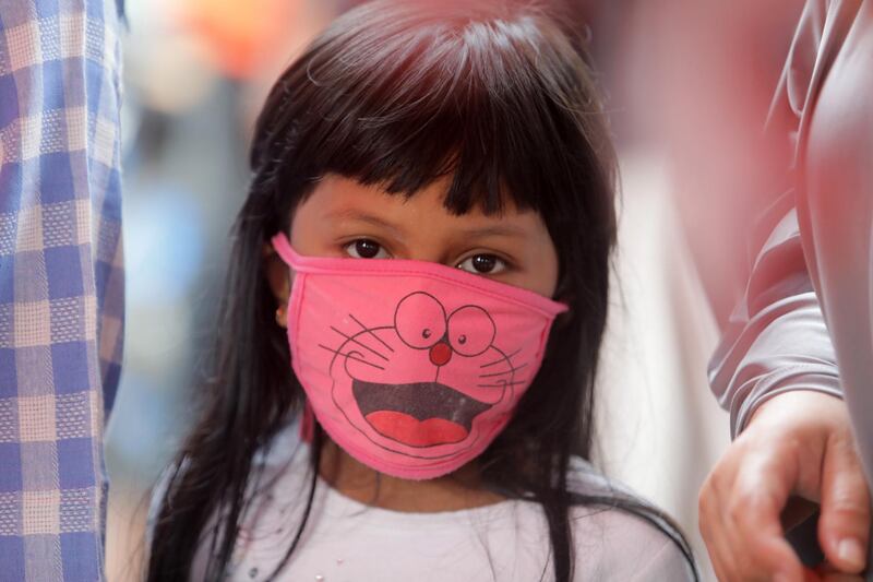 An Indonesian child wears a hand made protective mask at a temporary meat market, ahead of Ramadan in Banda Aceh, Indonesia.  EPA