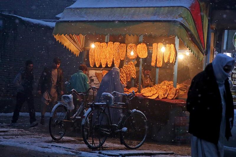 An Afghan woman buys bread from a street vendor during a snow storm in Kabul, Afghanistan. Massoud Hossaini / AP Photo