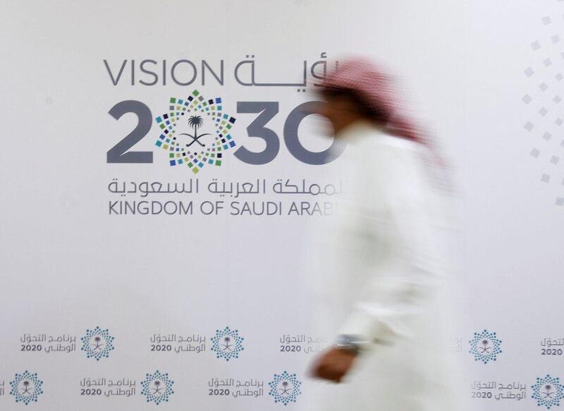 A Saudi man walks past the logo of Vision 2030 after last night's news conference, in Jeddah. Faisal Al Nasser / The National