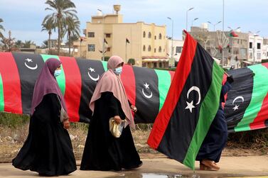 A Libyan woman carries a national flag in the capital Tripoli on February 25, 2021, during celebrations commemorating the 10th anniversary of the 2011 revolution that toppled Muammar Qaddafi. AFP 