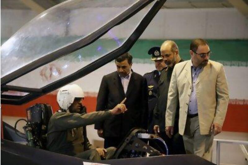 Mahmoud Ahmadinejad, Iran's president, centre, listens to a pilot during a ceremony to unveil Iran's newest fighter jet on Saturday. Mehr News Agency, Younes Khani / AP Photo