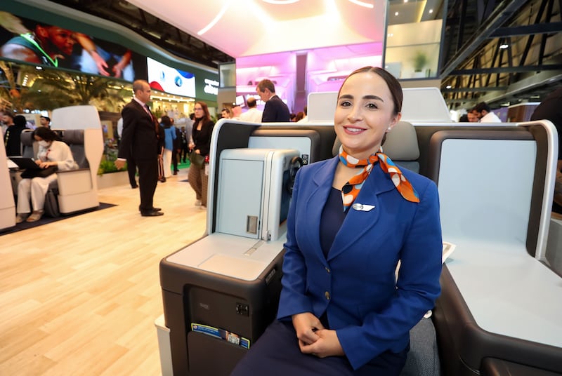 Flydubai cabin crew member Federica shows off business class seats at the airline's stand. Chris Whiteoak / The National