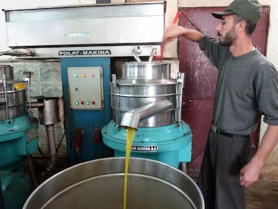 A Syrian man works a machine that makes olive oil in the village of Atme in the northwestern province of Idlib, on November 30, 2012. The farming village a stone's throw from Syria's northern frontier has been swelled by civilians displaced by the conflict which has ravaged the country for more than 19 months. AFP PHOTO / HERVE BAR (Photo by HERVE BAR / AFP)