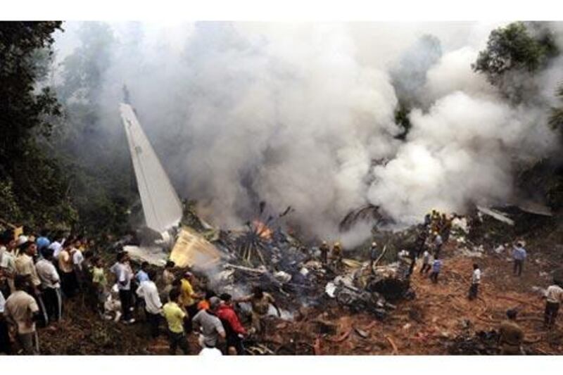 Civilians look on as Indian firefighters and rescue personnel gather around the site of an Air India plane that crashed in Mangalore, in the southern Indian state of Karnataka.